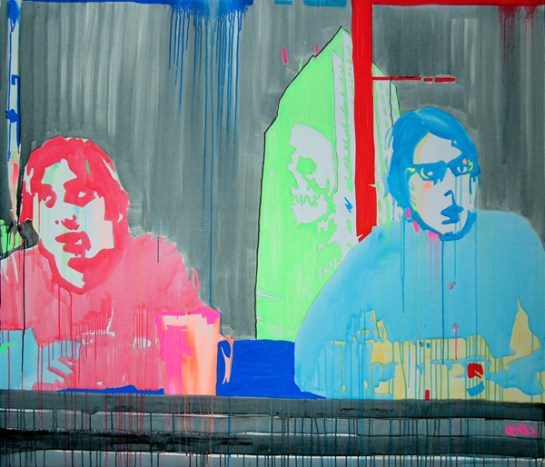 Two musicians sit behind dark stage equipment, one painted pink and one blue, with tall green and red panels behind them.