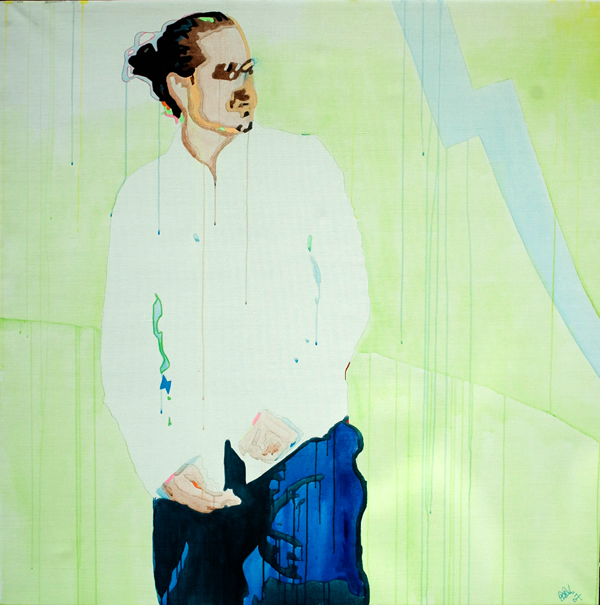 A man with hair tied back stands in a loose white shirt against a pale green stage, with dark blue forms gathered at his side.